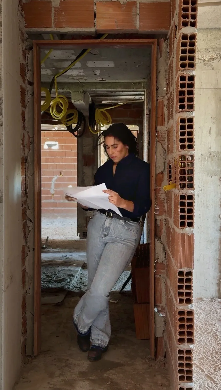 Engenheira da AMA Obra analisando plantas dentro da obra